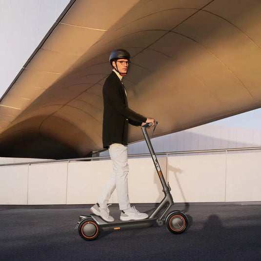 Model riding an ElitePrime electric scooter on the road